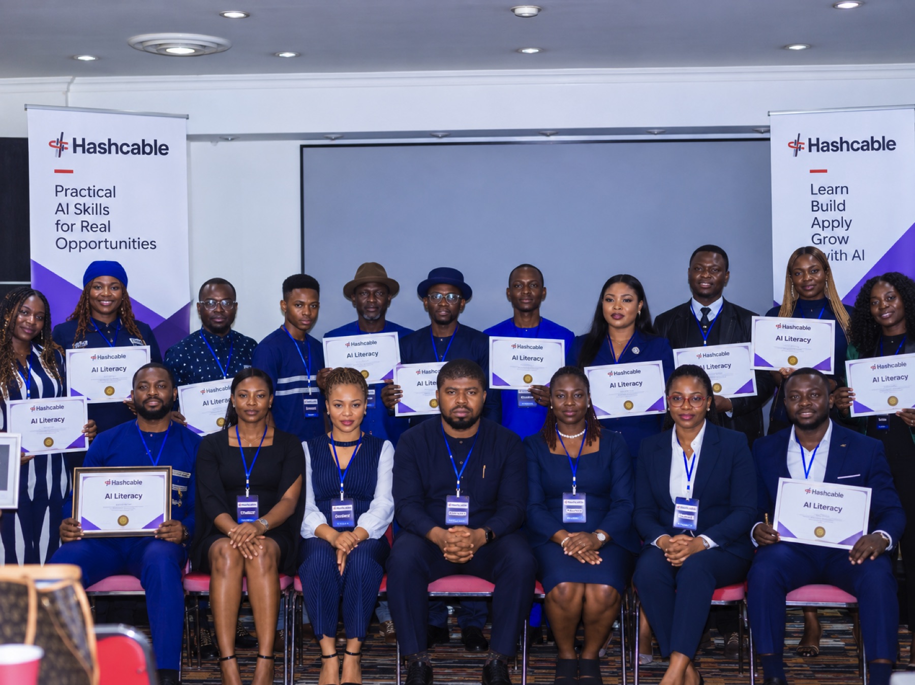 Hashcable Cohort 4 graduates holding their AI Literacy certificates at the in-person graduation event
